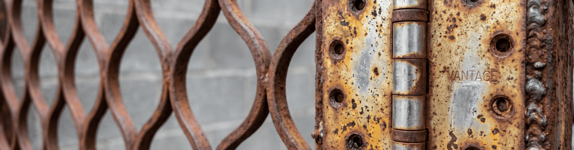 Detalle de bisagra y piezas metálicas oxidadas en un elemento exterior, utilizado para explicar cómo la humedad y el salitre pueden afectar a herrajes, tornillos y mecanismos cerca del mar.